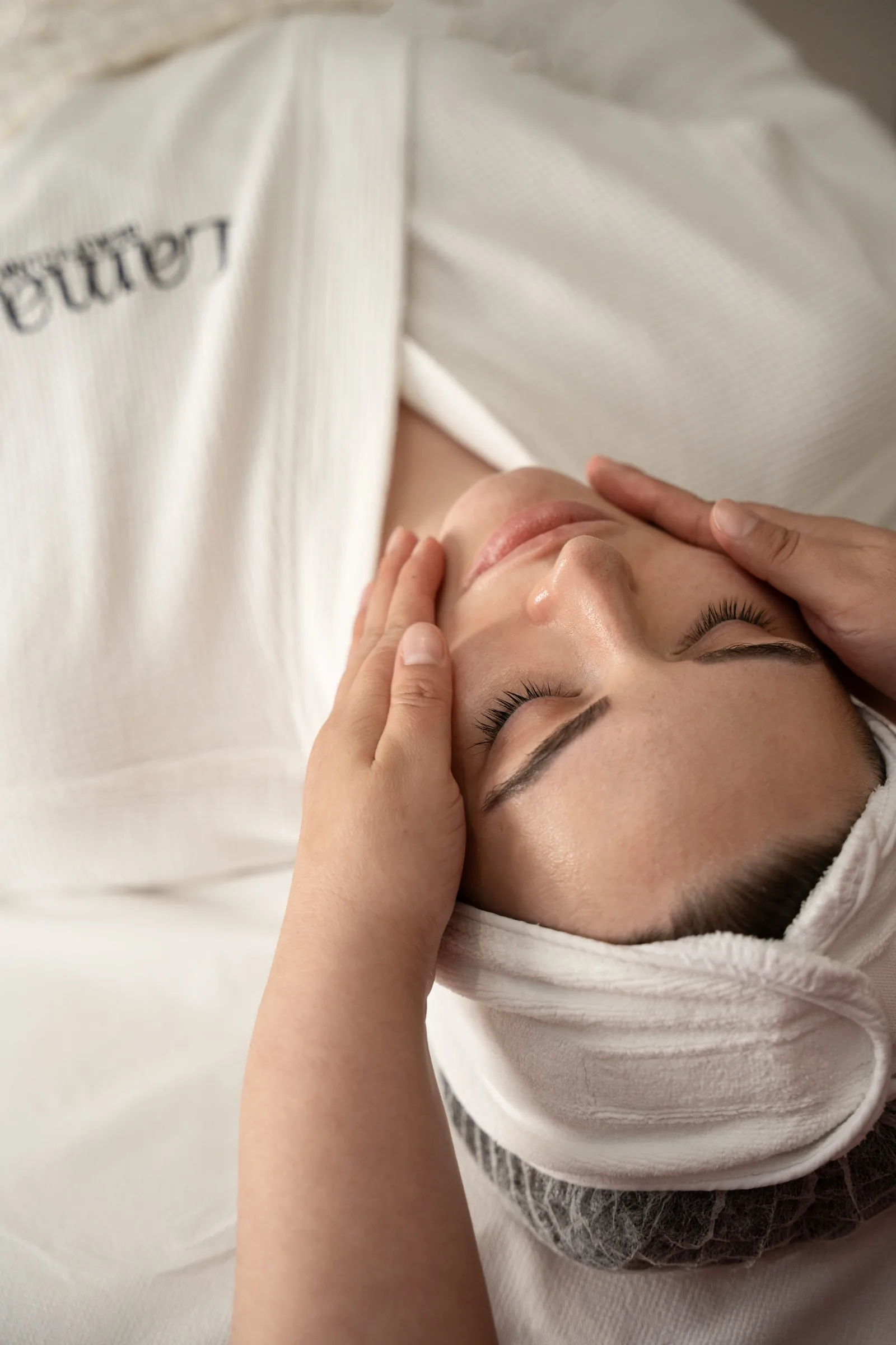 A therapist performing a facial massage at LMA
